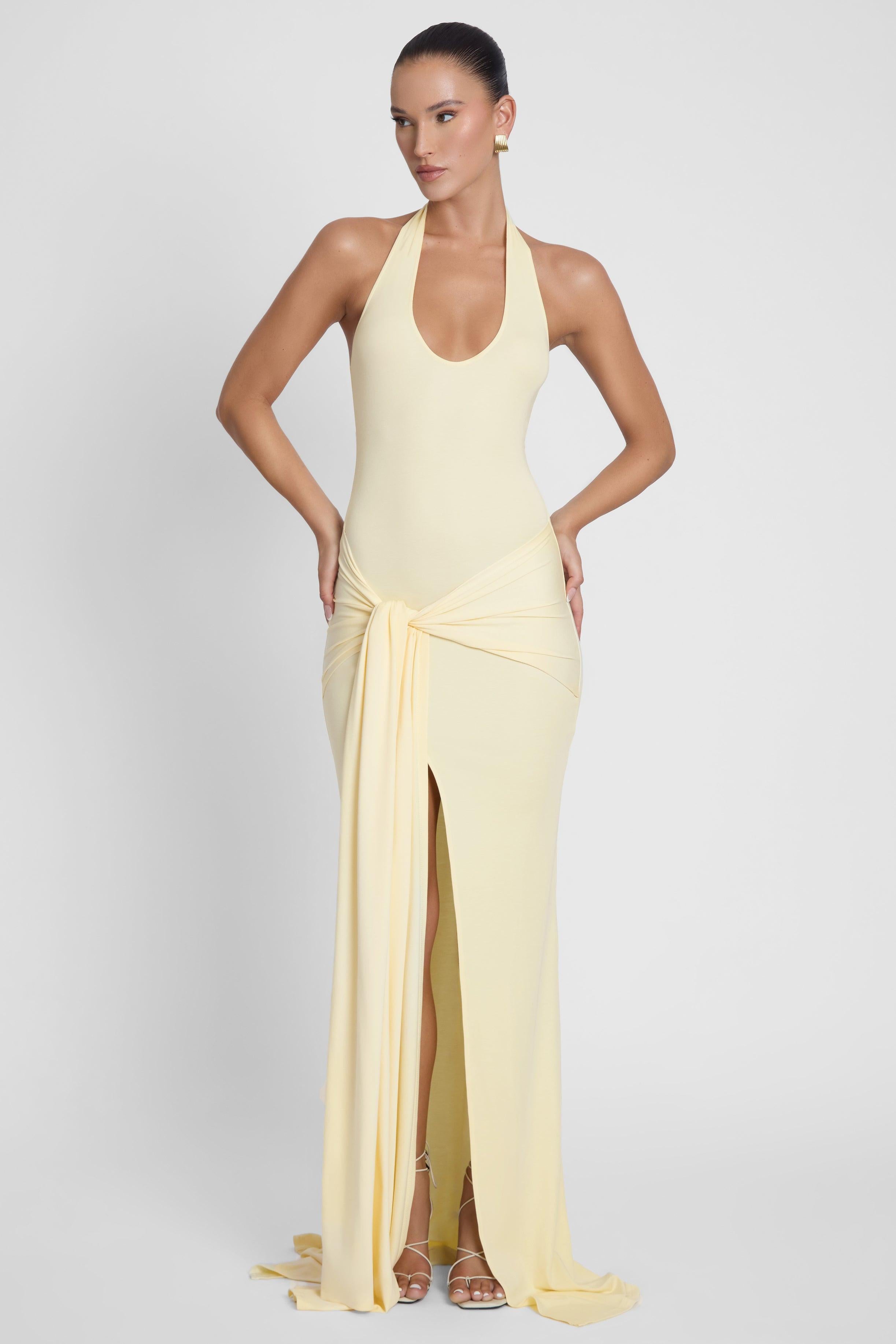 Model is wearing Heaven Halter Jersey Knot Maxi Dress Yellow, front view.